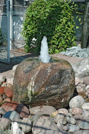 Brunnen grüngrauer Findling als Quellstein beleuchtetes Wasserspiel 